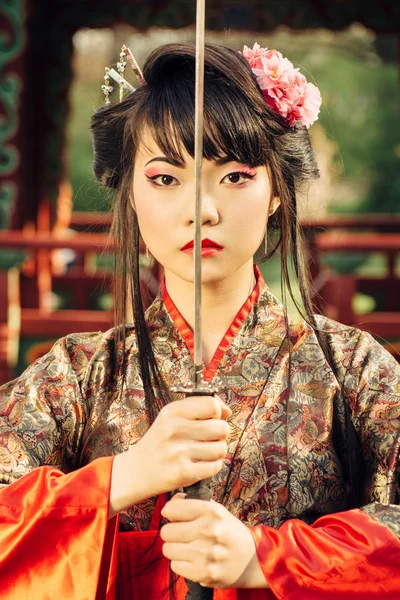 Beautiful geisha in kimono with samurai sword — Stock Photo, Image