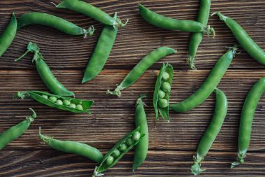 关闭整个新鲜豌豆和截面的仿古木制背景，顶视图