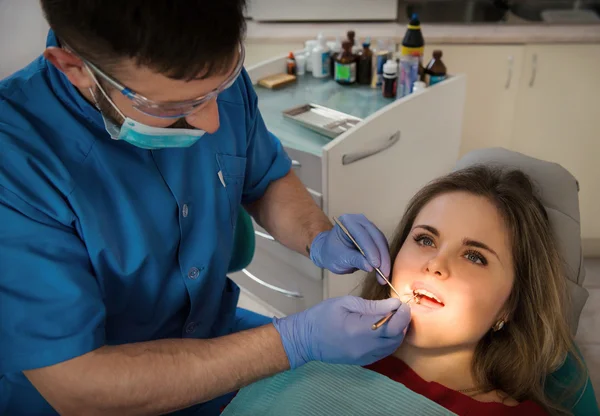 Male dentist examining a woman's teeth — Stock Photo, Image