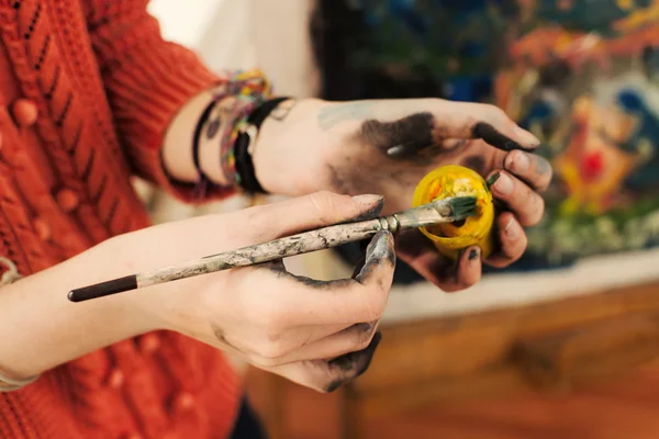 Brushes and oil paints in woman hands — Stock Photo, Image