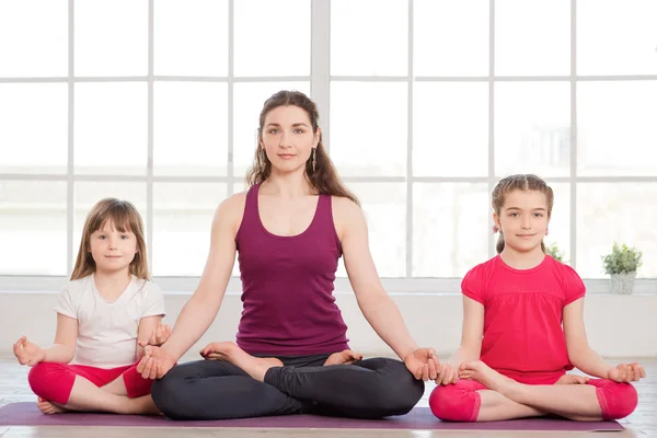 Junge Mutter und Töchter machen Yoga-Übungen — Stockfoto