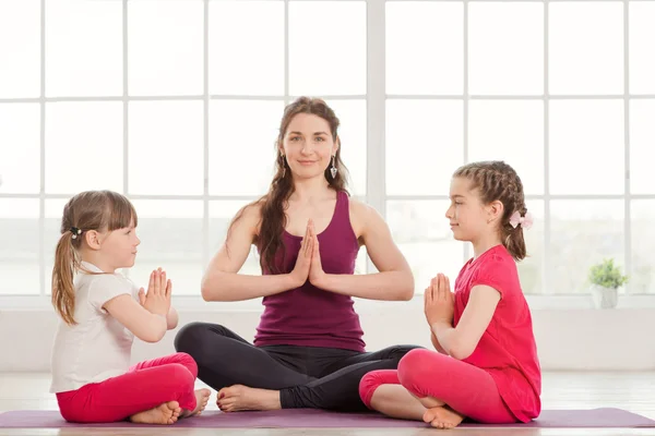 Jeune mère et filles faisant de l'exercice de yoga — Photo