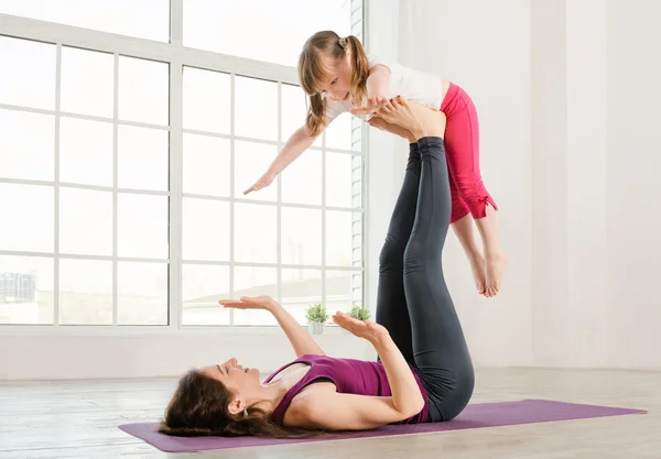 Giovane madre e figlia che fanno esercizio di yoga — Foto Stock