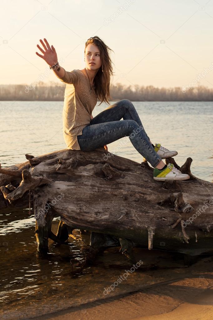 Young sensual woman near water on sunset