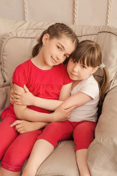 Two little girls sitting in a chair — Stock Photo, Image