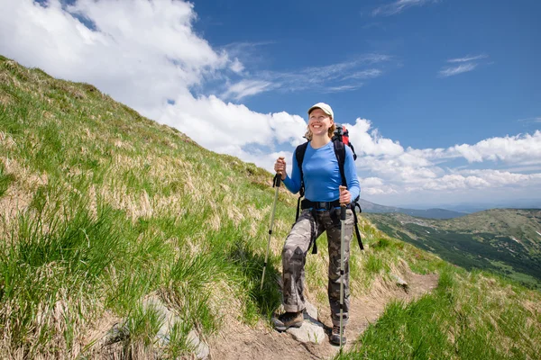 Woman hiking with sticks in Carpathian mountains — Stock fotografie