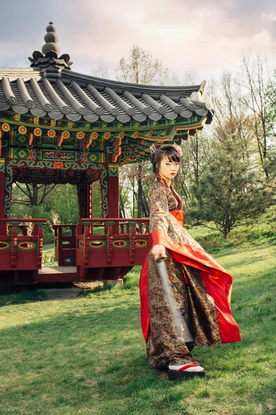 Beautiful geisha in kimono with samurai sword — Stock Photo, Image