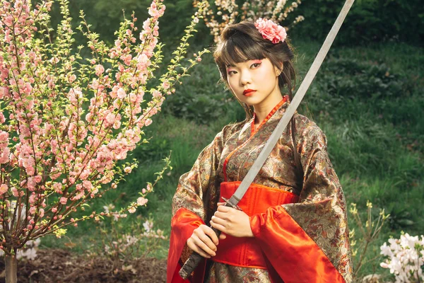 Beautiful geisha in kimono with samurai sword — Stock Photo, Image