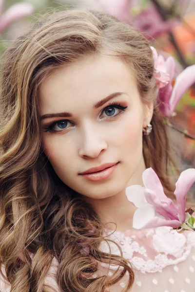 Kobieta piękna twarz z różowe kwiaty — Zdjęcie stockowe