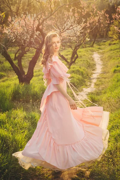 Atractiva mujer en vestido rosa disfrutando de la naturaleza —  Fotos de Stock