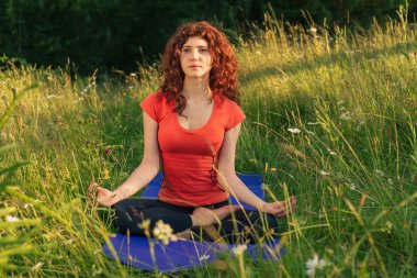 Genç kadının doğada yoga egzersizleri yapması