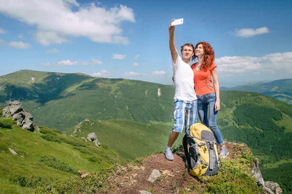 Casal feliz fazendo selfie nas montanhas Fotos De Bancos De Imagens