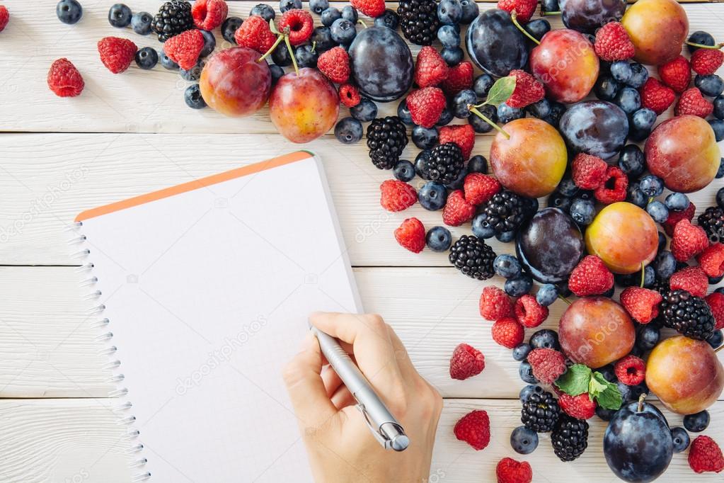 Shopping list with mixed fruit and ingredients from top view
