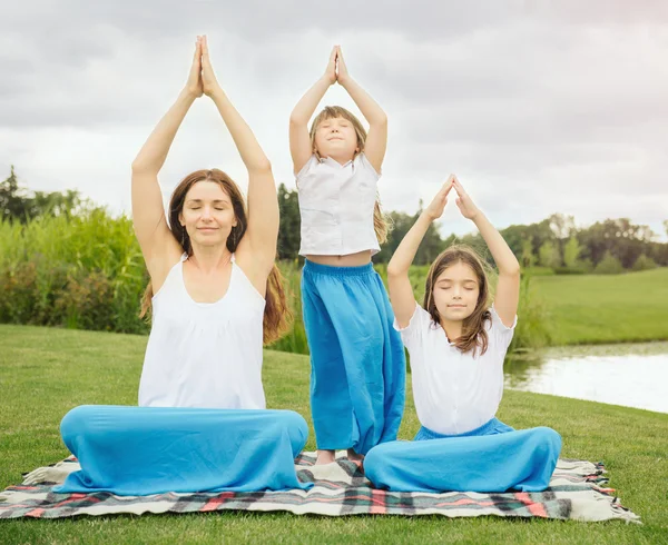 Mutter mit Tochter macht Yoga-Übungen — Stockfoto