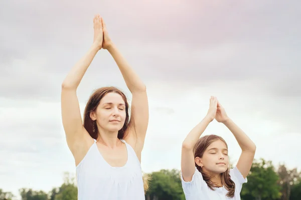 Mutter mit Tochter macht Yoga-Übungen — Stockfoto