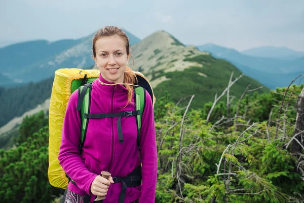 Žena, turistika s trekingové hole a batoh — Stock fotografie