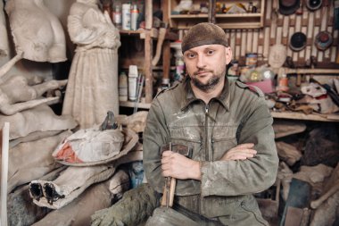 Portrait of sculpture man in his home studio