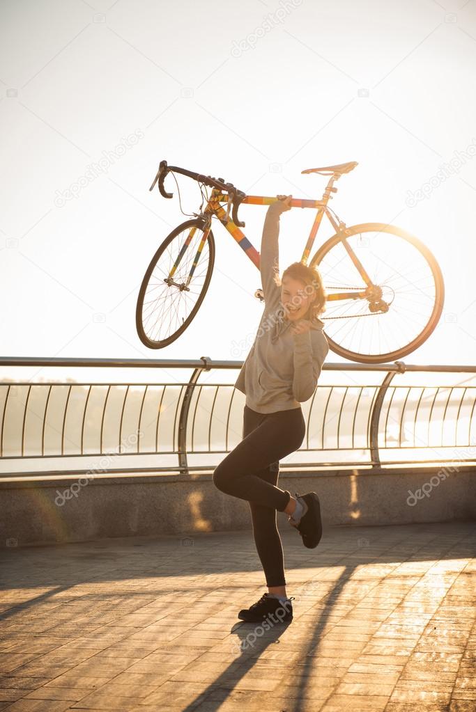 Happy woman and bike in the city