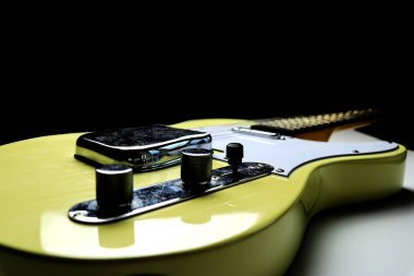 Klasik sarı - siyah arkaplan üzerinde sarışın bitiş gitarı - yakın plan