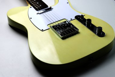 Beyaz arkaplanda sarı renkli elektro gitar - yakın plan