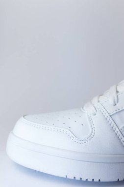 Beyaz arka planda beyaz spor ayakkabının ön tarafı - beyaz ayakkabıyı kapat - dikey