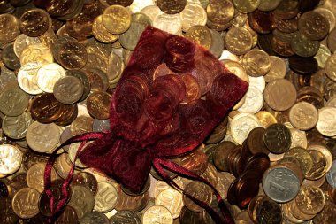 Bozuk paraların arka planında kırmızı torba