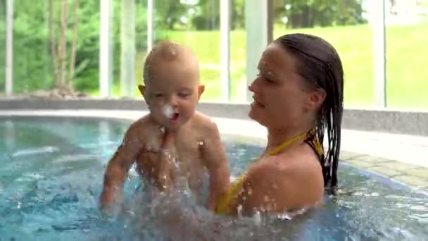 Una Madre Lindo Bebé Una Piscina Cubierta Bebé Salpicando Agua — Vídeo de stock