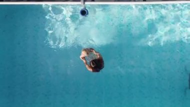 Havuzda bir anne ve bir bebek. İHA görüntüsü tüm mahalleyi gösteriyor.