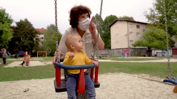 Una Mujer Con Máscara Médica Balanceando Niño Columpio Covid Coronavirus — Vídeos de Stock