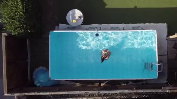 Una madre y un bebé en una piscina. Lanzamiento de drones elevando mostrando todo el vecindario — Vídeos de Stock