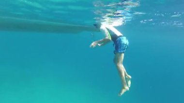 Çocuk teknenin altında yüzüyor ve kafasını çarpıyor.