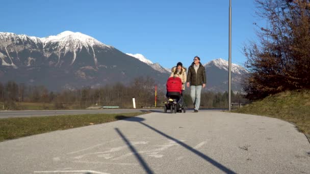 Een koppel met een wandelend kinderwagen — Stockvideo