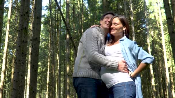 Молода вагітна пара в красивому зеленому лісі — стокове відео