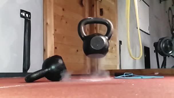 Een kettlebell valt en stuitert terug van een rubberen vloer. Superslowmotion — Stockvideo