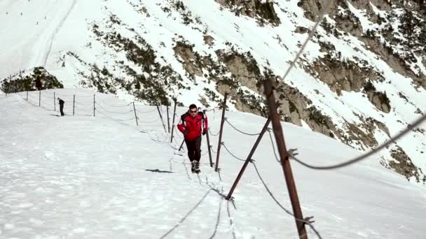 Mężczyzna Czerwonej Kurtce Okularach Słonecznych Biegający Głębokim Śniegu Szczycie Góry — Wideo stockowe