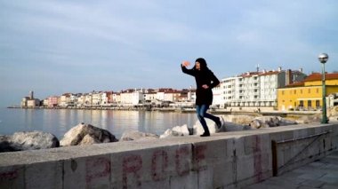 Rıhtımda koşan bir kadın bir tekneyi durdurmaya çalışıyor.