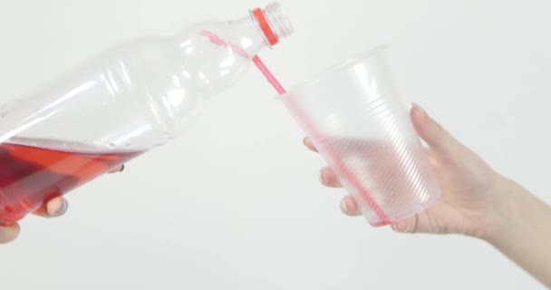 Žena nalévá červený ovocný nápoj z plastové láhve do sklenice. — Stock video