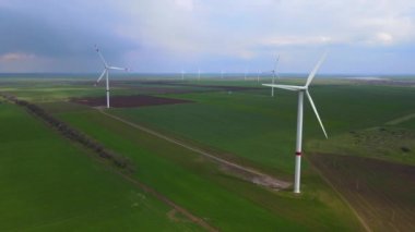 Sürdürülebilir kalkınma için temiz yenilenebilir enerji üreten rüzgar çiftlikleri. Alternatif enerji. Geniş rüzgar türbinleri. Havada bıçaklar var..