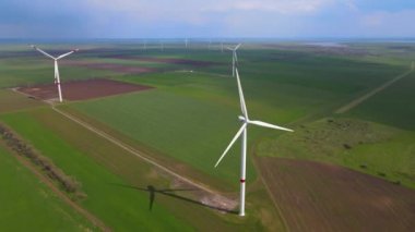 Sürdürülebilir kalkınma için temiz yenilenebilir enerji üreten rüzgar çiftlikleri. Alternatif enerji. Geniş rüzgar türbinleri. Havada bıçaklar var..