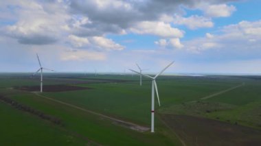 Sürdürülebilir kalkınma için temiz yenilenebilir enerji üreten rüzgar çiftlikleri. Alternatif enerji. Geniş rüzgar türbinleri. Havada bıçaklar var..