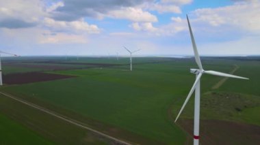 Sürdürülebilir kalkınma için temiz yenilenebilir enerji üreten rüzgar çiftlikleri. Alternatif enerji. Geniş rüzgar türbinleri. Havada bıçaklar var..