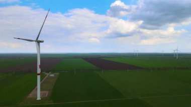Sürdürülebilir kalkınma için temiz yenilenebilir enerji üreten rüzgar çiftlikleri. Alternatif enerji. Geniş rüzgar türbinleri. Havada bıçaklar var..