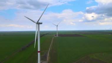 Sürdürülebilir kalkınma için temiz yenilenebilir enerji üreten rüzgar çiftlikleri. Alternatif enerji. Geniş rüzgar türbinleri. Havada bıçaklar var..