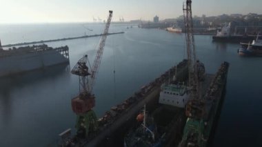 İskele rıhtımındaki ticaret ihracatındaki bir kargo gemisinin hava görüntüsü. Derin su limanına yükleme ve boşaltma, ticari lojistik ithalat ve ihracat kargo taşımacılığının hava görüntüsü