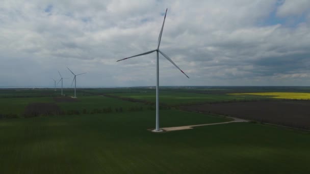 飛行場内にブレードを持つ大型風力タービン青い空の風公園スローモーションドローンターン 風車のシルエット 夏のレンズ 代替エネルギー — ストック動画