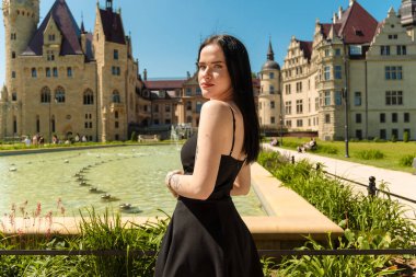 Kalenin arka planında siyah elbiseli güzel bir kız.