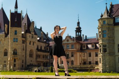 Kalenin arka planında siyah elbiseli güzel bir kız.