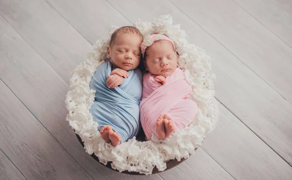 双子は生まれたての兄弟姉妹です 新生児の少女と少年 バスケットの中で甘い眠り — ストック写真