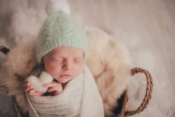 一个新生的男孩睡着了 手里拿着一颗白色的针织的心 — 图库照片