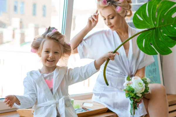 funny mom and daughter in curlers play